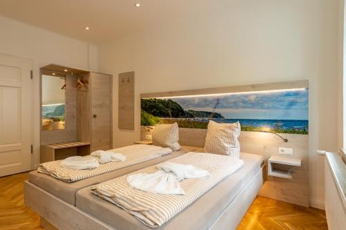 two beds in a room with a view of the ocean at Villa Sand im Schuh in Ostseebad Sellin