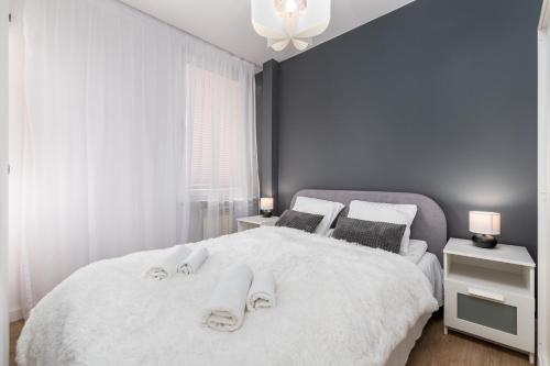 a bedroom with a white bed with towels on it at Darwina 3A by Homeprime in Warsaw