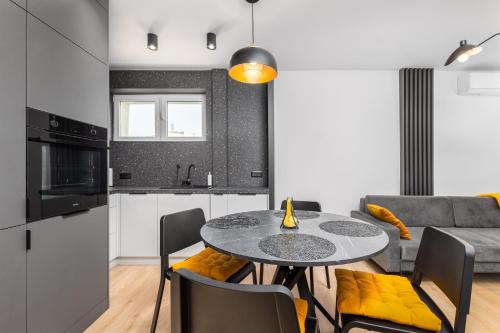 a kitchen and living room with a table and chairs at Darwina 3A by Homeprime in Warsaw