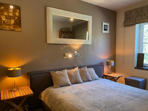 a bedroom with a bed with two lamps and a mirror at Roja apartment Baltic in Roja