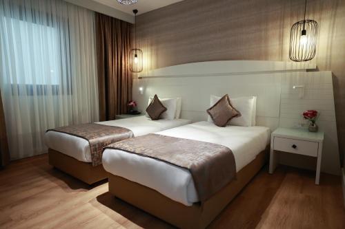 a hotel room with two beds and a window at Nova Plaza Orion Hotel in Istanbul