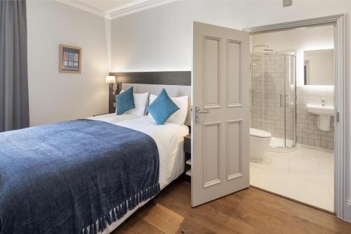 a bedroom with a bed and a bathroom with a shower at Notting Hill House in London