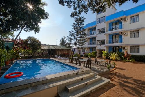 una piscina con un frisbee frente a un edificio en Aastha Escape Resort near Calangute Beach, en Calangute