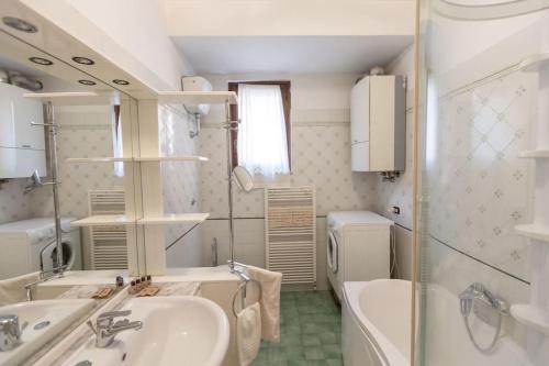 a bathroom with a sink and a tub and a toilet at Caldora Apartment in LʼAquila