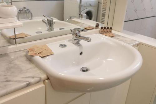 a white sink in a bathroom with a mirror at Caldora Apartment in LʼAquila
