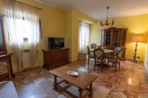 a living room with a couch and a table and chairs at Caldora Apartment in LʼAquila