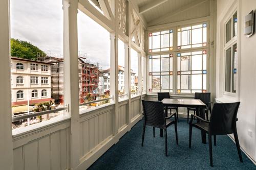 a balcony with a table and chairs and windows at Villa Sand im Schuh in Ostseebad Sellin