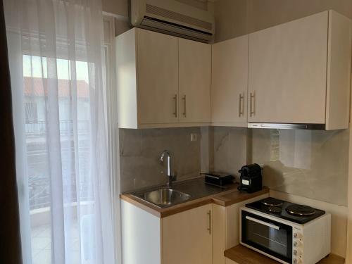 a small kitchen with a sink and a microwave at Vryzas Resort in Ofrínion