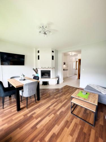 a living room and dining room with a table and a couch at Apartament Leśny z kominkiem - Viva Pod Giewontem Apartamenty in Zakopane