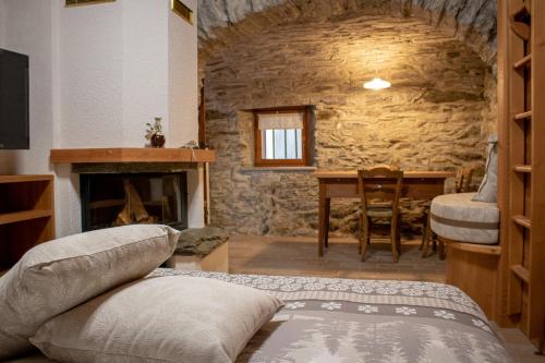 a room with a bed and a stone fireplace at Busc De Crodol in Comune Rivamonte Agordino