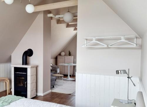 ein Schlafzimmer mit weißen Wänden, einem Kamin und einem Tisch in der Unterkunft Villa Marienholm in Haapsalu