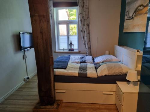 Schlafzimmer mit einem Bett und einem Fenster in der Unterkunft Ferienwohnung Noltenius in Bülstedt
