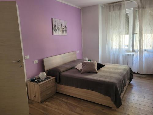 een slaapkamer met een bed en een paarse muur bij Casa Dany in Albissola Marina