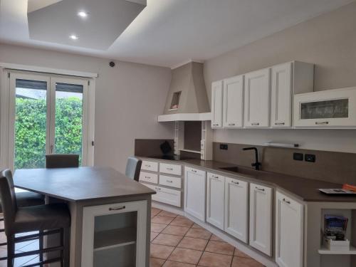 a kitchen with white cabinets and a table at Suite vacanze Chabloz nel cuore della Valle d'Aosta in Nus