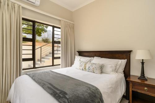 a bedroom with a bed and a large window at Vredehoek Guest Farm in Breerivier
