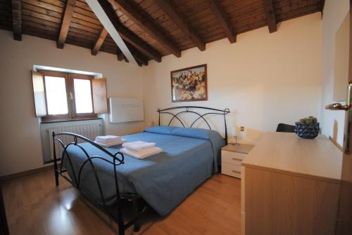 - une chambre avec un lit doté d'un couvre-lit bleu dans l'établissement Appartamento Ciagoli, à Bogliaco