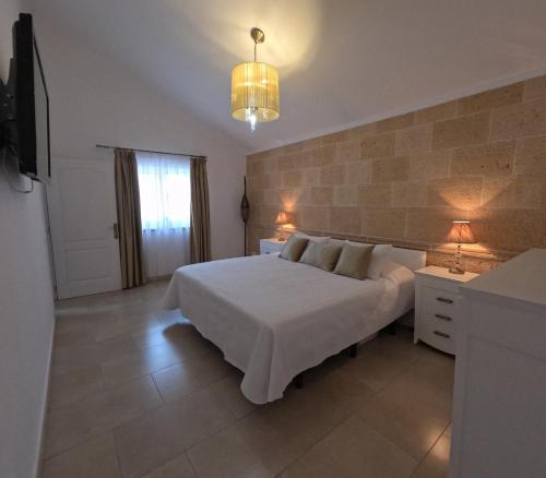 a bedroom with a large white bed and a television at Casa Paraiso Villa Tenerife, stunning family bungalow with totally secluded pool area, wheelchair friendly in San Miguel de Abona