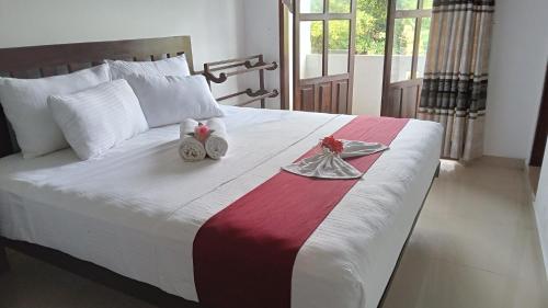 Un dormitorio con una cama con toallas y flores. en Villa Sanitha, en Ambalangoda