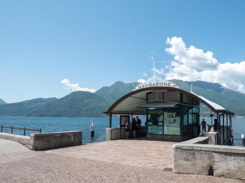 a kiosk on a pier next to a body of water at Camelia House in Bellano
