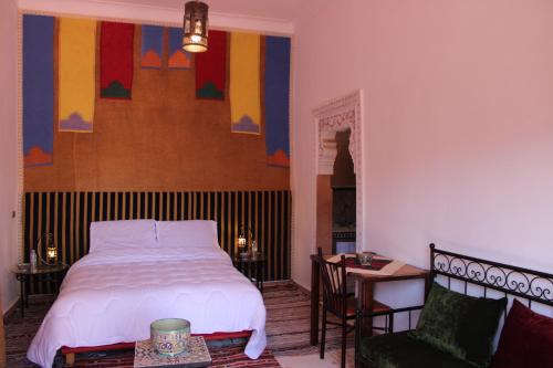 El Jemʼa Ghemat的住宿－Villa DALIA Route Ourika en Exclusivité，卧室配有1张床、1张桌子和1把椅子