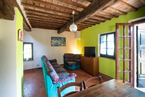 ein Wohnzimmer mit grünen Wänden sowie einem Tisch und Stühlen in der Unterkunft ROSMARINO in Città della Pieve