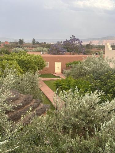 un jardin avec un bâtiment en arrière-plan dans l'établissement Upupa de l’Atlas, à Marrakech