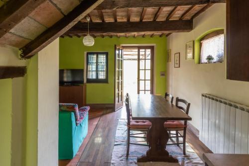 ein Esszimmer mit grünen Wänden sowie einem Tisch und Stühlen in der Unterkunft ROSMARINO in Città della Pieve