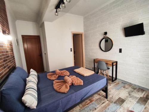 a bedroom with a blue bed with towels on it at Grecos STAY SKIATHOS in Skiathos Town