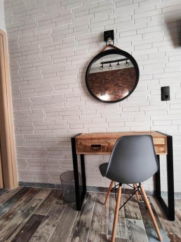 a mirror on a wall with a desk and a chair at Grecos STAY SKIATHOS in Skiathos Town
