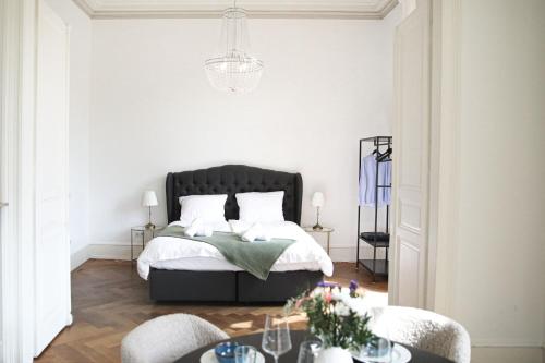 a bedroom with a bed and a table with chairs at Palais Passy~Design Suite mit Ausblick im Zentrum in Wiesbaden