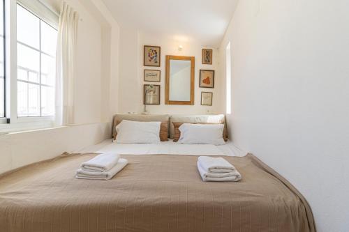 a bedroom with a large bed with two towels on it at Top Ático Plaza del Arenal - Gran terraza - Vistas - Solarium in Jerez de la Frontera