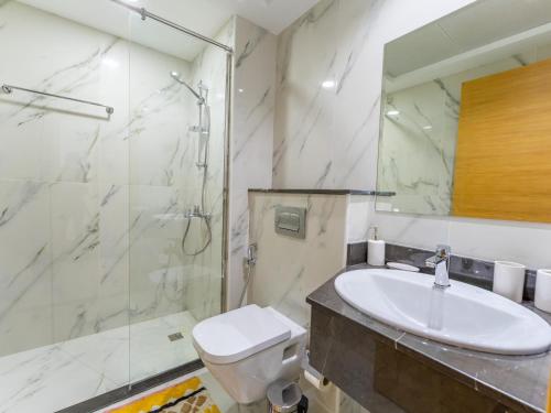 a bathroom with a toilet and a sink and a shower at Large 2BR w Wooden floor 2 min Access Highway in Dubai