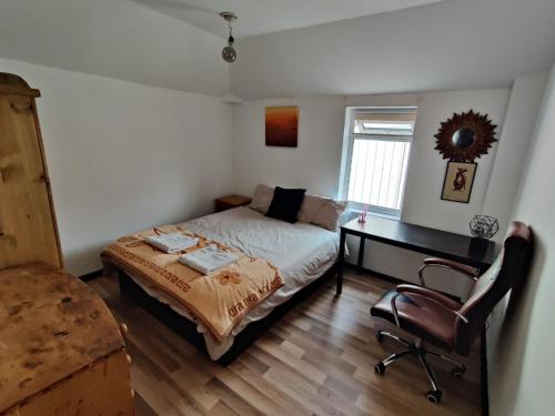 a bedroom with a bed and a desk and a chair at Unique antique 2BR@Hackney canal in London