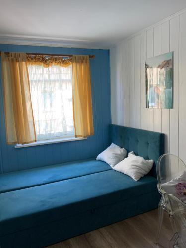 a blue couch in a room with a window at Pokoje U Hanki in Dziwnów