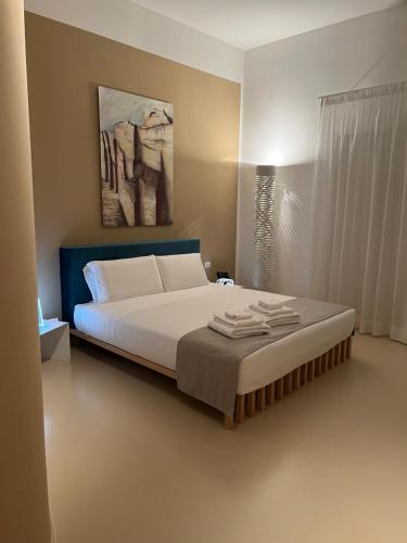a bedroom with a large bed with a painting on the wall at Hotel Cave Del Sole in Matera