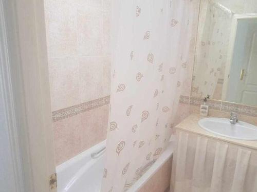 een badkamer met een bad, een wastafel en een bad bij 610 precioso apartamento cerca del mar in Los Amarguillos