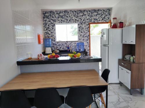uma cozinha com uma mesa e um frigorífico branco em Casa Unamar Cabo Frio-RJ em Cabo Frio