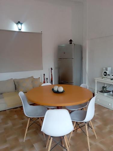 a kitchen with a wooden table and white chairs at San Cayetano in San Salvador de Jujuy