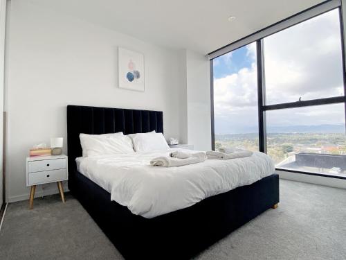 a bedroom with a large bed with a large window at Skygarden Luxury Condo in Glen Waverley