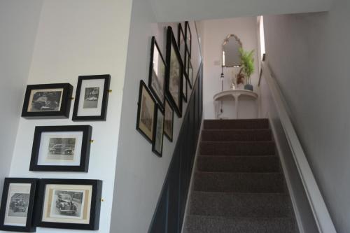 a stairway with framed pictures on the wall at 2 Barbour Court in Lisburn