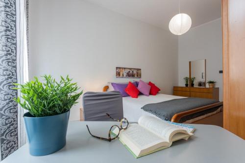 um quarto com uma cama com um livro e copos sobre uma mesa em A Casa di Enza by Wonderful Italy em Turim