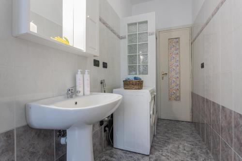 uma casa de banho branca com um lavatório e um WC em A Casa di Enza by Wonderful Italy em Turim
