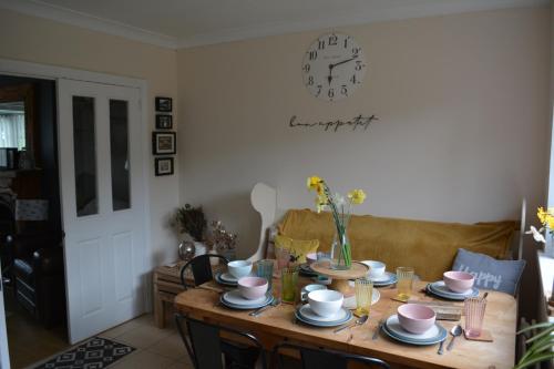 a dining room table with a clock on the wall at 2 Barbour Court in Lisburn