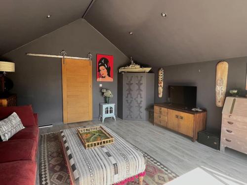 a living room with a couch and a tv at Eclectic Barn - Pergola & Dog-Friendly Garden in Calne