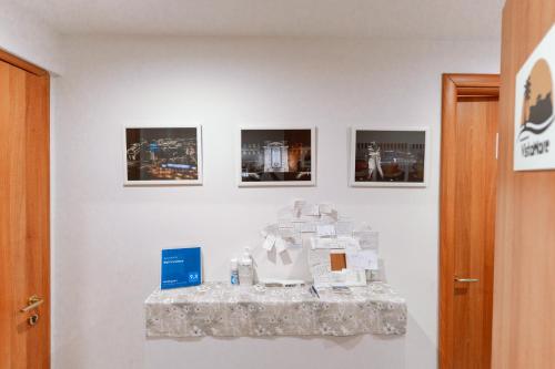 a white wall with three pictures on it at B&B VistaMare in Civitavecchia