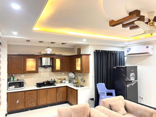 a kitchen with a couch and a black refrigerator at LUXURY 6 Bedroom Holiday Home in Islamabad