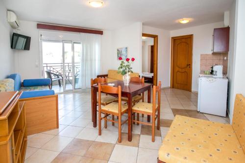 a kitchen and living room with a table and chairs at Apartments Lina in Potos