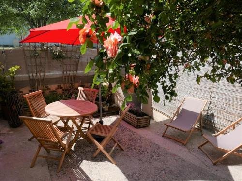 a table and chairs with a red umbrella at Gite les trois matelots in Fécamp