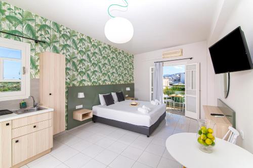 a bedroom with a bed and a sink and a television at Sunshine Studios in Malia