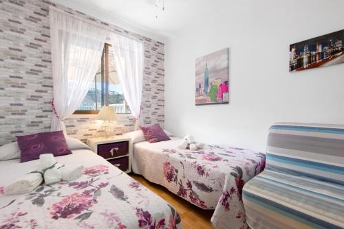 a bedroom with two beds and a window at Jolly suite puertorico Beach in Mogán